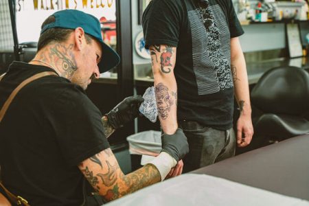 Long Beach Tattoo Artist working on American traditional design